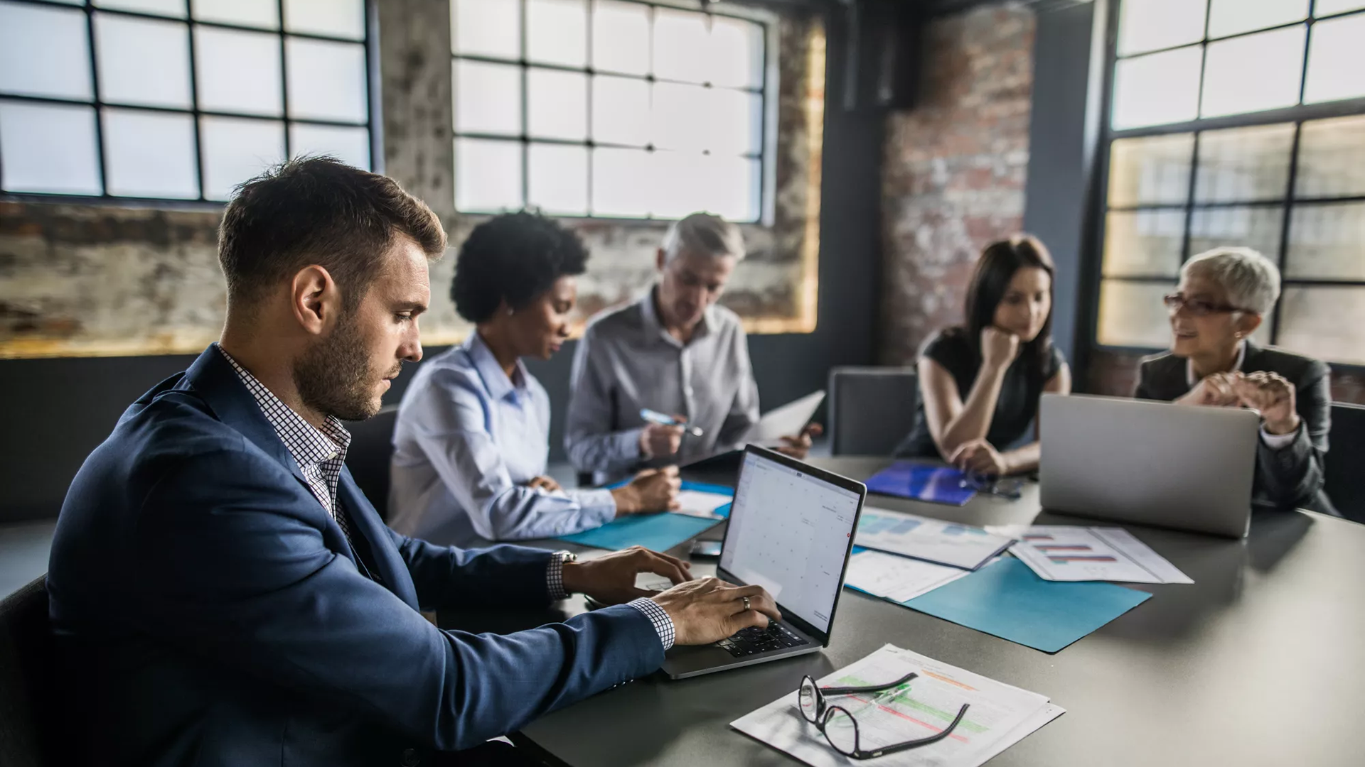 Compañeros trabajando en una mesa de reuniones