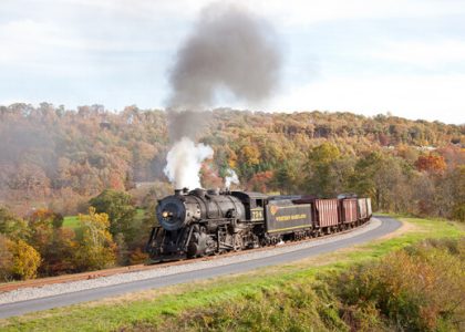 Tren de vapor cruzando un valle, con árboles de Maryland de fondo.