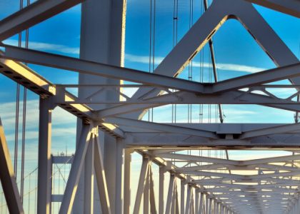 Vigas y estructura de soporte de un puente, con un fondo de cielo azul.