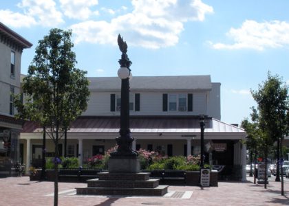 Una plaza en Delaware con un monumento y una tienda.