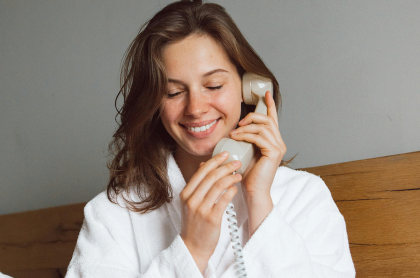 Mujer sosteniendo un teléfono junto a la oreja