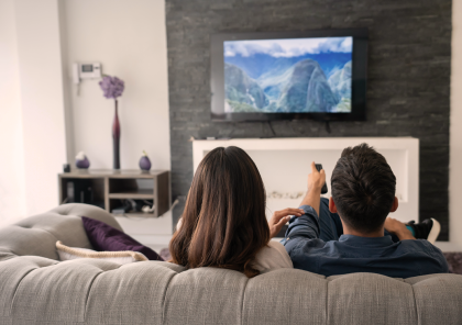 Una pareja sentada en un sofá mira televisión