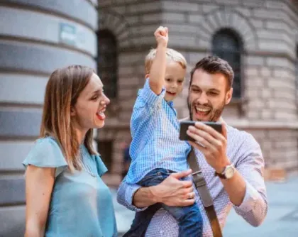 Familia que mira teléfono y celebra