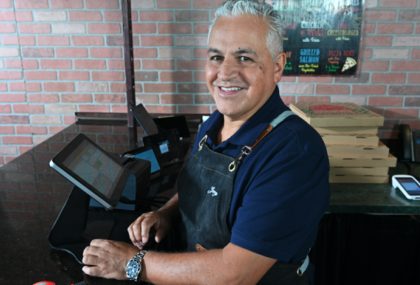 Hombre sonriendo detrás de una barra