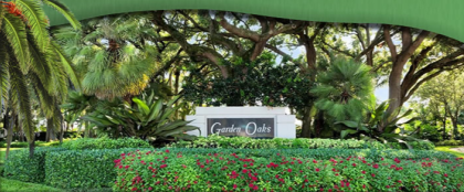 Cartel de Green Oaks entre varios árboles y arbustos.