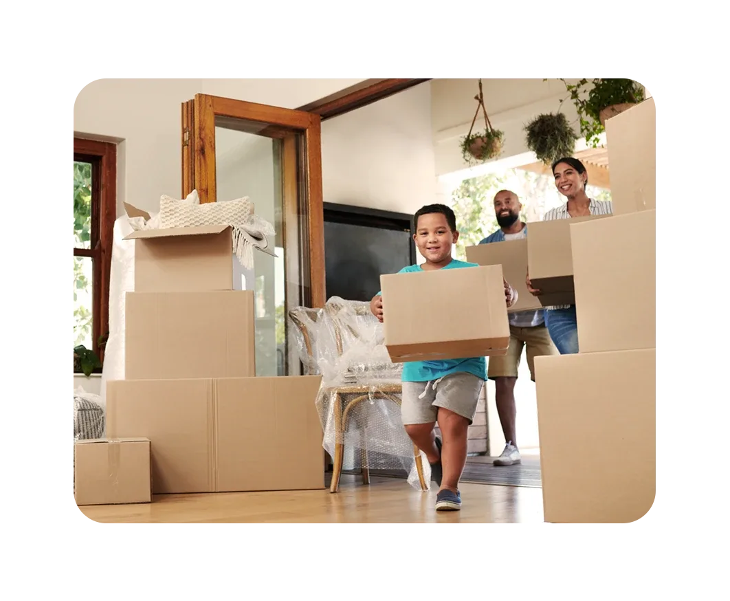 Familia mudándose a su nueva casa con cajas en las manos, niño corriendo emocionado