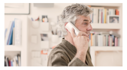 Hombre sosteniendo un teléfono fijo junto al oído