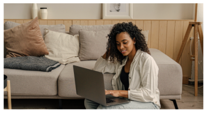 Mujer mirando su computadora portátil mientras está sentada en el piso