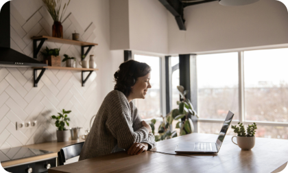 Woman sitting in a kitchen with laptop