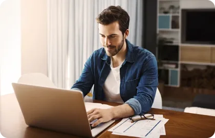 Un hombre consulta los detalles del plan de Internet de Breezeline en una laptop