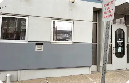 Interior de un centro comercial de varios niveles con tiendas, en donde aparece un kiosco de Breezeline.