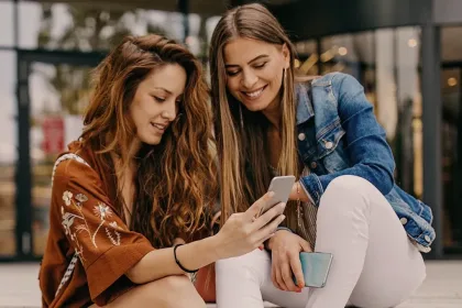 Dos personas navegando en un teléfono.