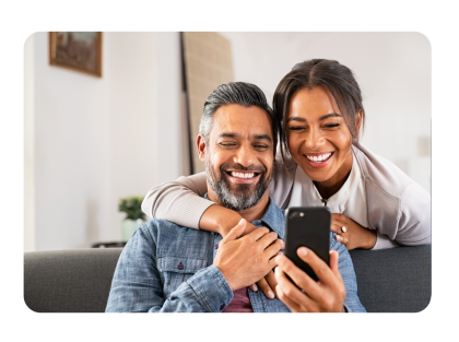 Man and woman looking at a mobile phone and smiling