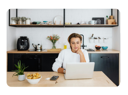 Mujer en la cocina mirando una laptop