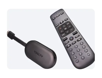 Un adaptador de streaming de DIRECTV en gris oscuro con un conector HDMI aparecen junto a un control remoto de DIRECTV a juego, con botones de navegación estándar y de control por voz.