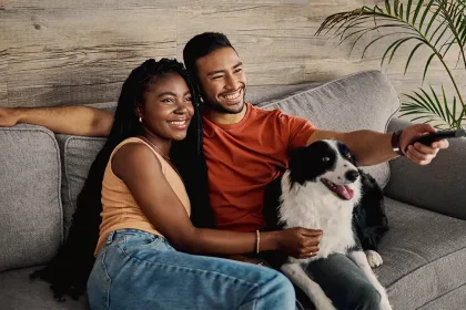 Una pareja viendo TV juntos en un sofá.