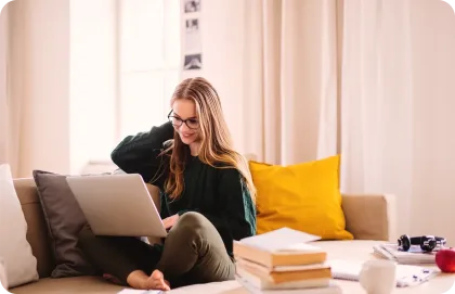 Chica mirando una laptop y sonriendo