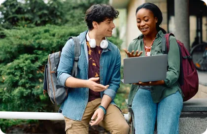 Hombre y mujer mirando una laptop al aire libre