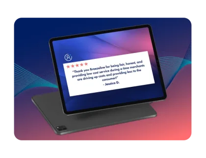 Una tablet muestra la reseña de 5 estrellas de la cliente Jessica D. donde le agradece a Breezeline por un servicio justo, transparente y de bajo costo.