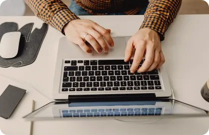 Una persona escribiendo en su laptop.